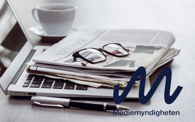 Newspaper with computer on table