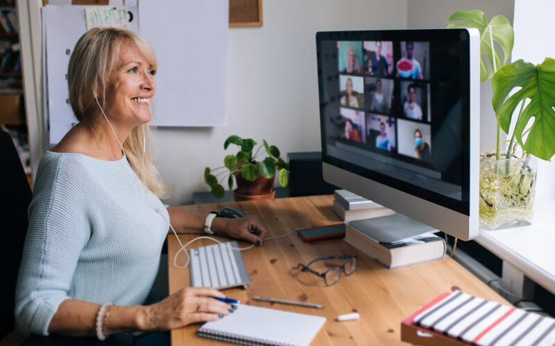 Smiling mature woman having video call via computer in the home